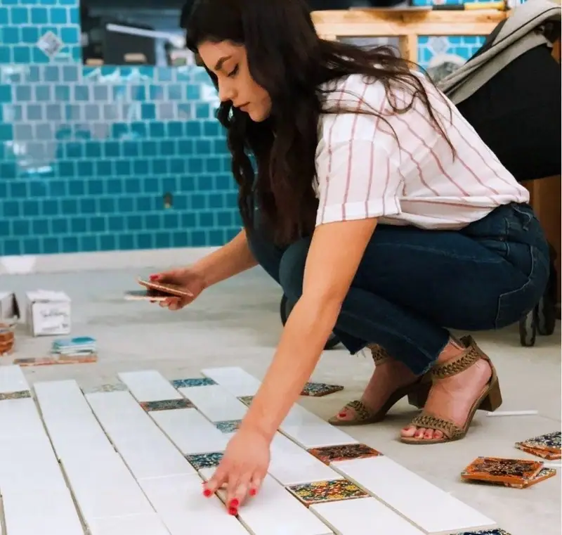 Woman arranging tile and flooring samples on a work table
